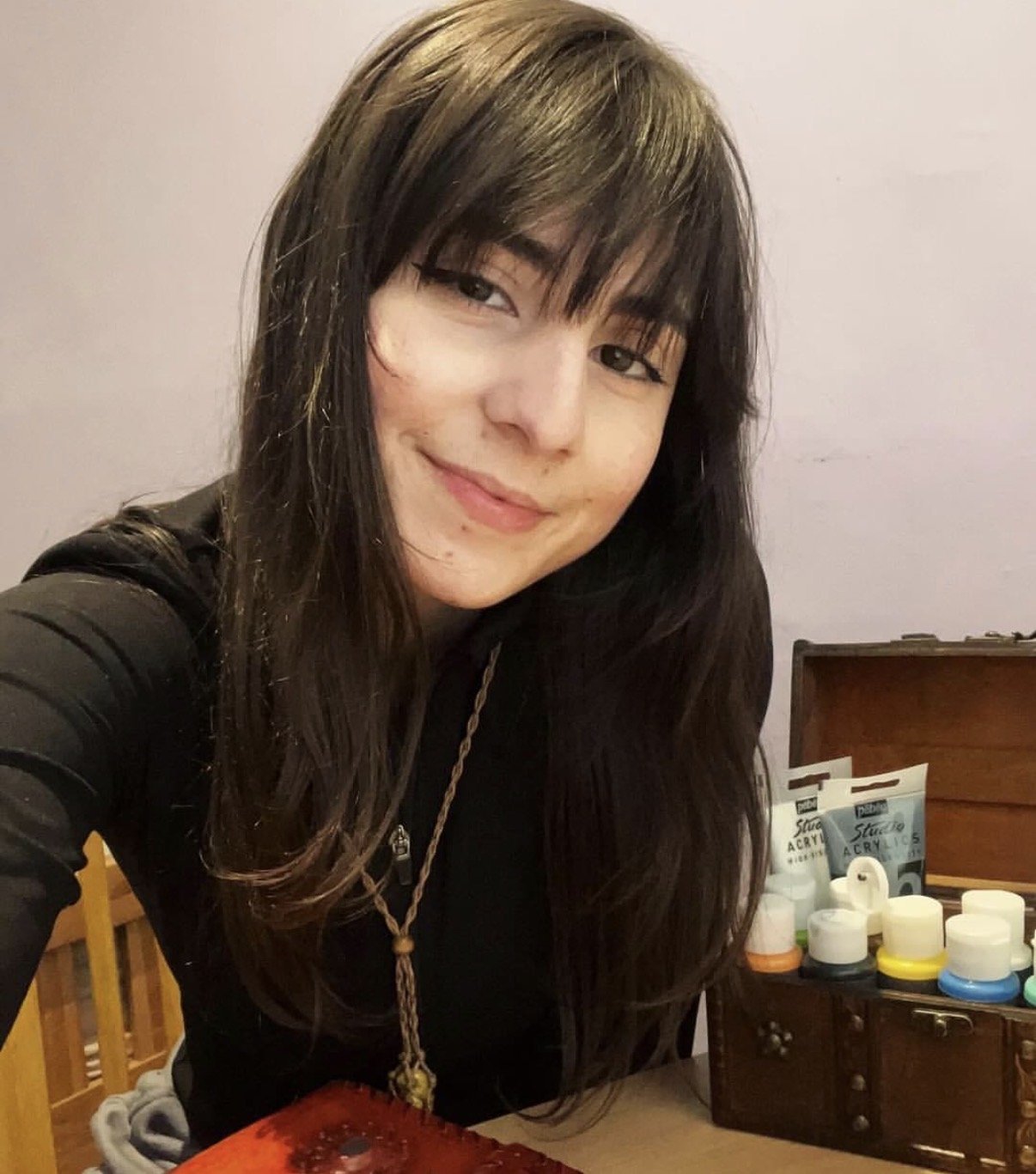 Izzie Del Real artist portrait with painting materials